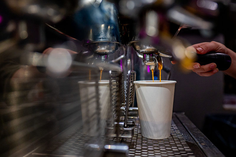 Espresso being poured into a cup by a barista.