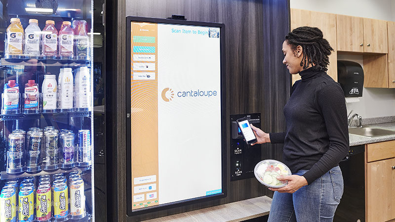 Woman pays with credit card at a Go Max kiosk