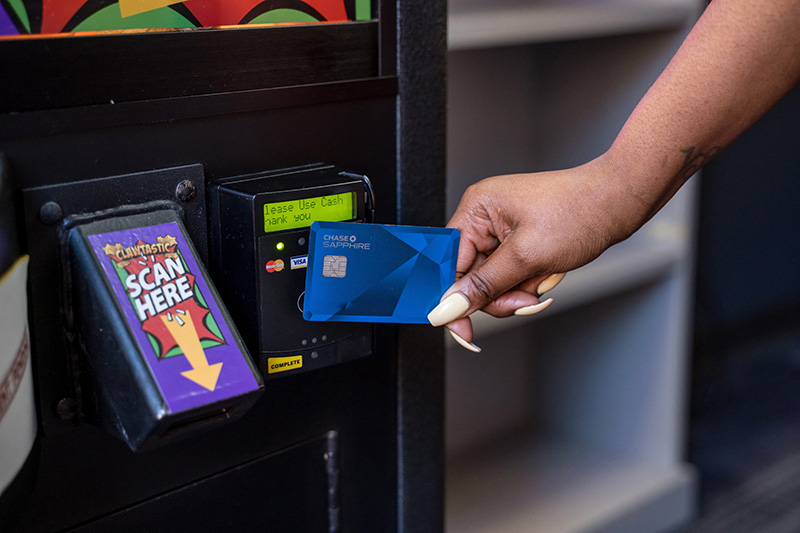 Woman taps to pay at claw machine card reader