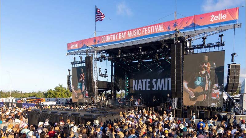 Country music festival stage with large crowd.