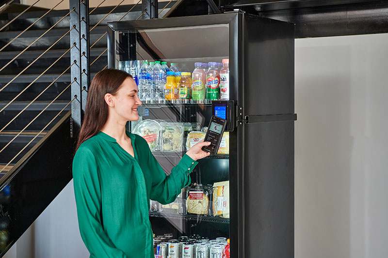 A woman pays with a mobile wallet at a Cooler Cafe.
