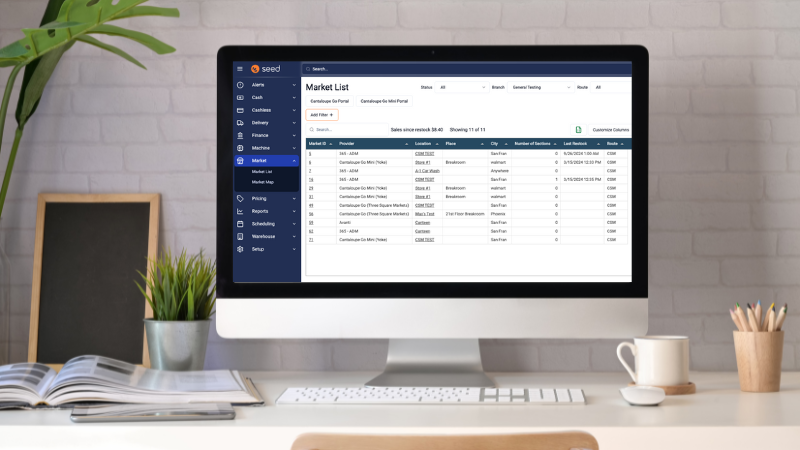 A desk with computer screen with Seed Pro's market's list page.
