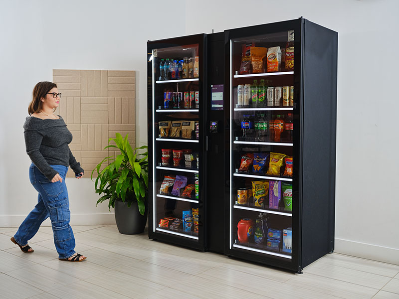 A woman walks up to a Smart Store in an office building lobby.