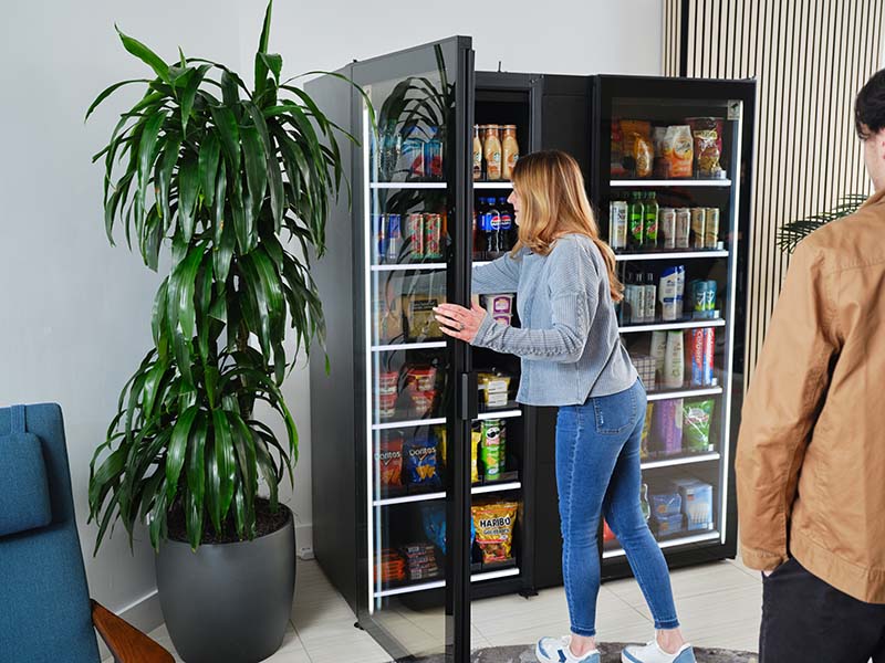 A mother and son pick out items from a Smart Store in a multifamily residential building.