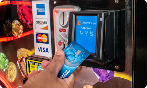 A customer taps to pay at a claw machine with an Engage Pulse.