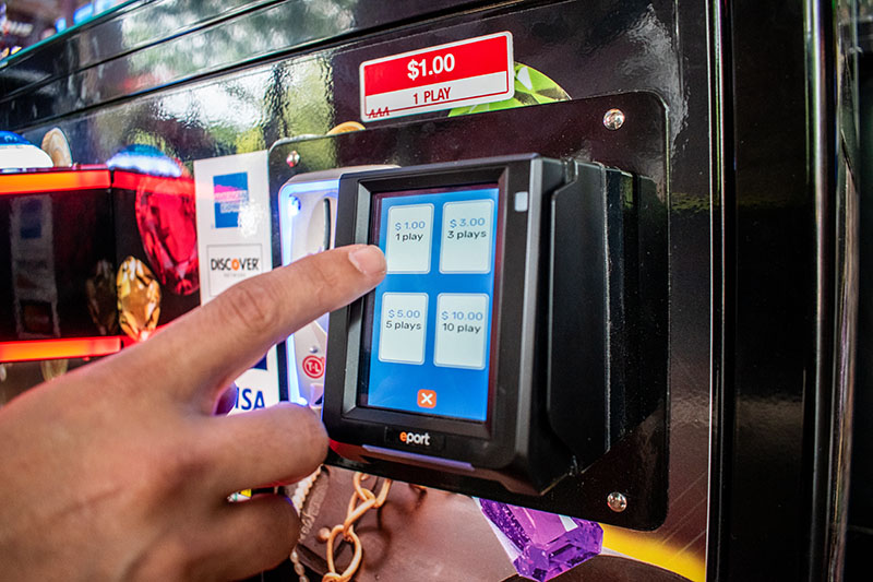 Customer selects from ladder pricing at an Engage Pulse on a claw machine.